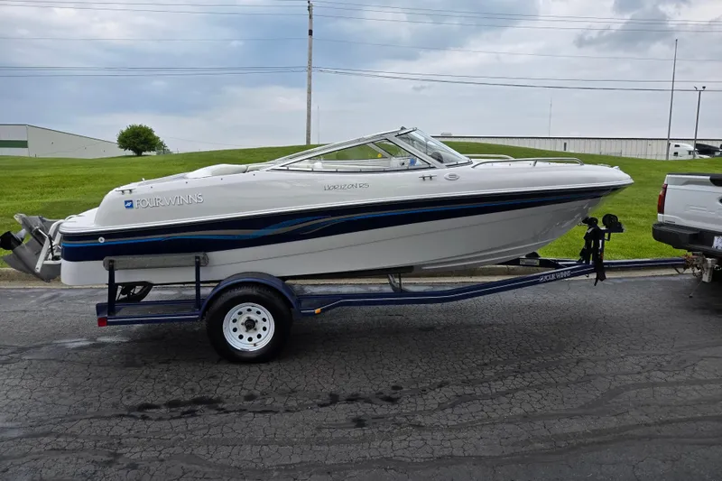 Slide: The Image of 1998 Four Winns 180 Horizon boat on trailer, parked outdoors on a cloudy day. - 4