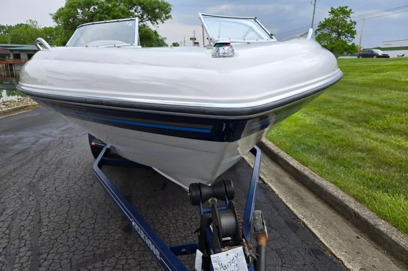 Slide: The Image of 1998 Four Winns 180 Horizon boat on trailer, parked on paved road. - 6