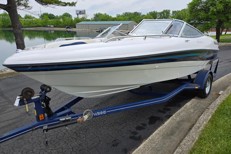 Slide: The Image of 1998 Four Winns 180 Horizon boat on trailer by a lakeside road. - 8