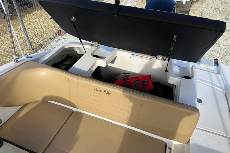 Slide: The Image of 2020 Sea Ray SPX 190 Outboard boat with open storage compartment and tan seating. - 10
