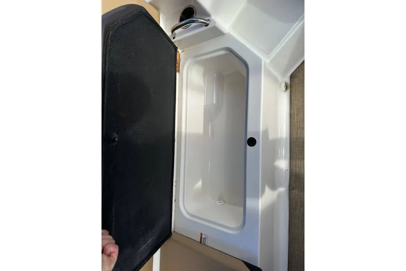 Slide: The Image of 2020 Sea Ray SPX 190 Outboard storage compartment with open lid. - 15