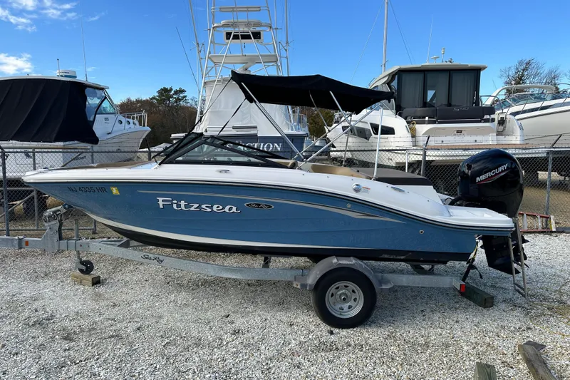 Slide: The Image of 2020 Sea Ray SPX 190 Outboard boat on trailer, blue hull, parked in marina. - 18