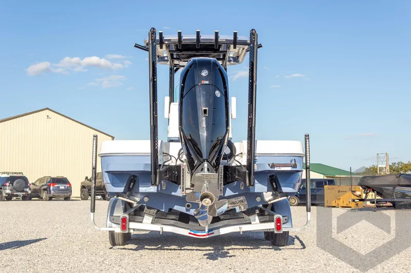 Slide: The Image of 2026 Caymas 26 HB boat on trailer, rear view, outdoor setting. - 17