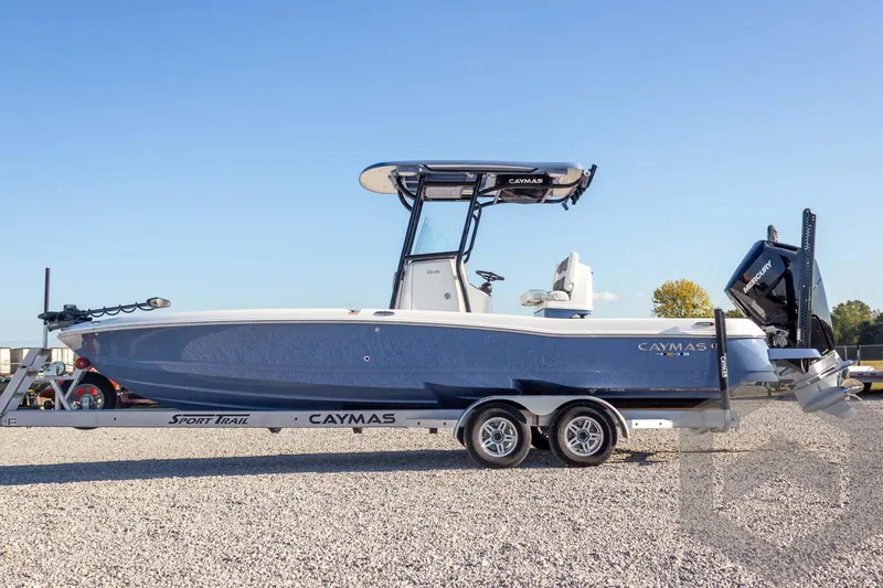 Slide: The Image of 2026 Caymas 26 HB boat on trailer, blue hull, clear sky background. - 19