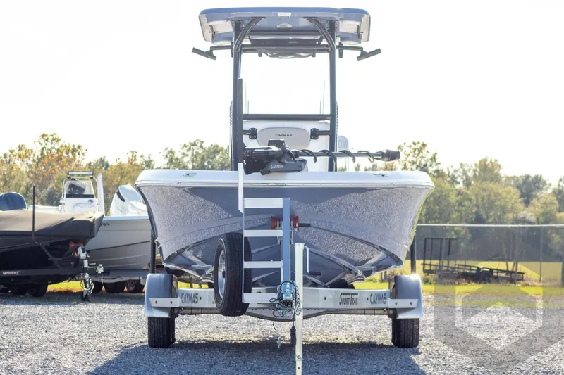 Slide: The Image of 2026 Caymas 26 HB boat on trailer, parked outdoors on gravel. - 2