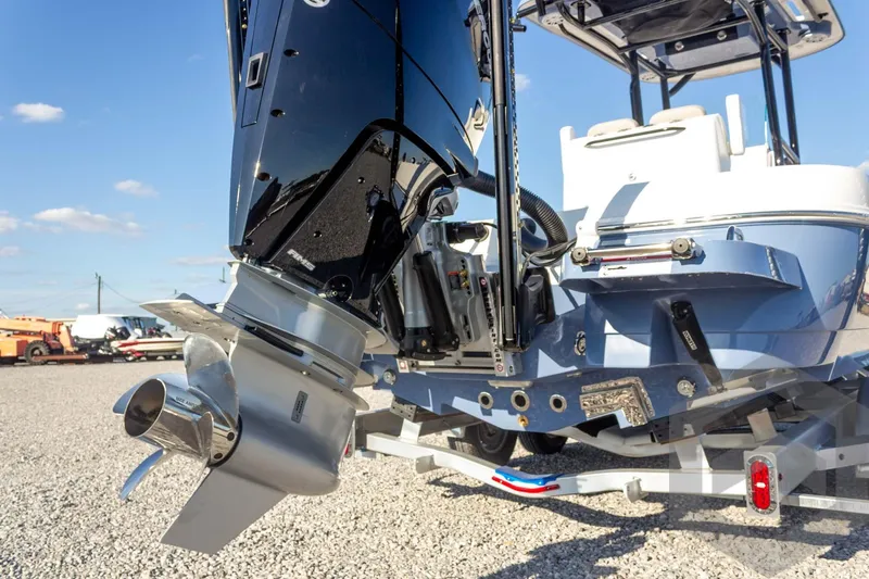 Slide: The Image of 2026 Caymas 26 HB boat with powerful outboard motor, displayed on gravel lot. - 21