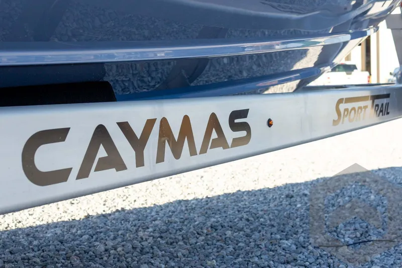 Slide: The Image of 2026 Caymas 26 HB boat trailer with "Sport Trail" branding on gravel surface. - 24