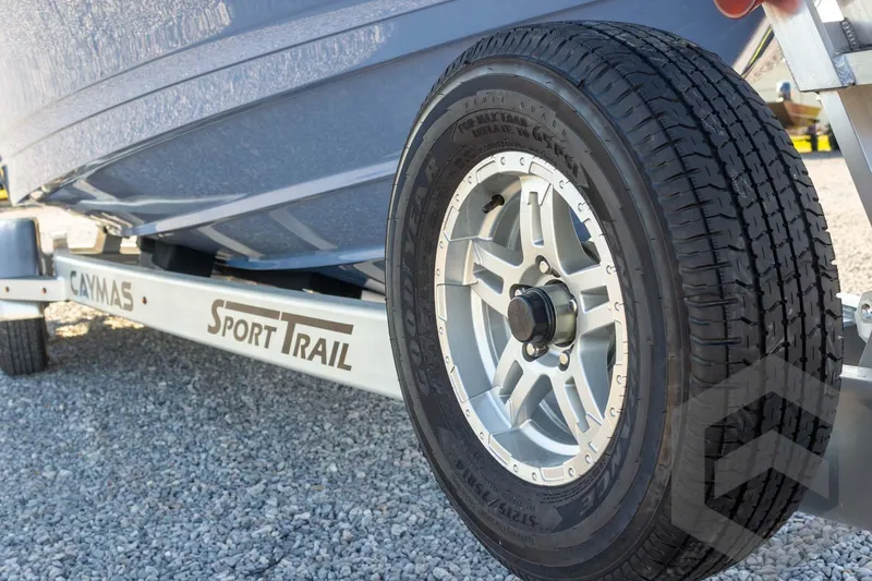 Slide: The Image of 2026 Caymas 26 HB boat on Sport Trail trailer, close-up of wheel and hull. - 25