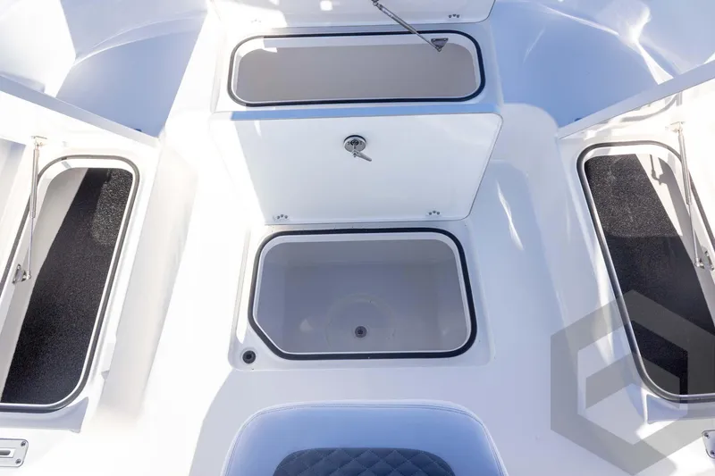 Slide: The Image of 2026 Caymas 26 HB boat storage compartments with open hatches, showcasing interior design. - 30