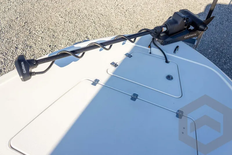 Slide: The Image of 2026 Caymas 26 HB boat deck with Garmin trolling motor, on gravel surface. - 34