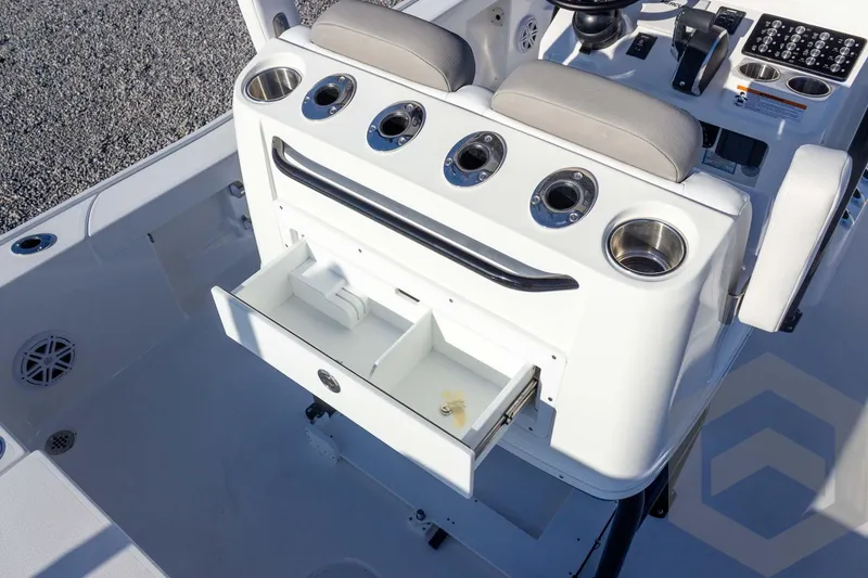 Slide: The Image of 2026 Caymas 26 HB boat console with open storage drawer and cup holders. - 43
