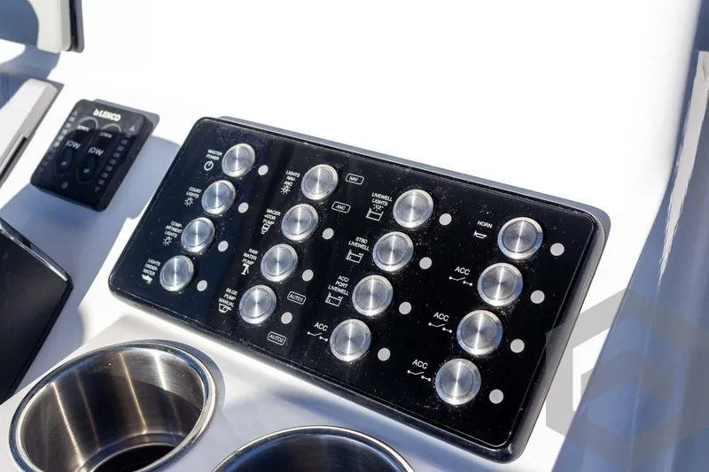 Slide: The Image of Control panel of 2026 Caymas 26 HB boat with various switches and cup holders. - 47