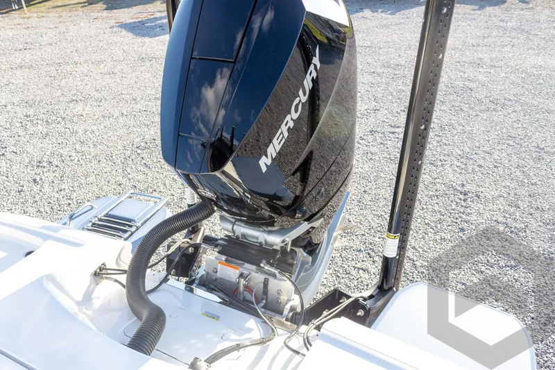 Slide: The Image of 2026 Caymas 26 HB boat with Mercury outboard engine, displayed on gravel surface. - 61