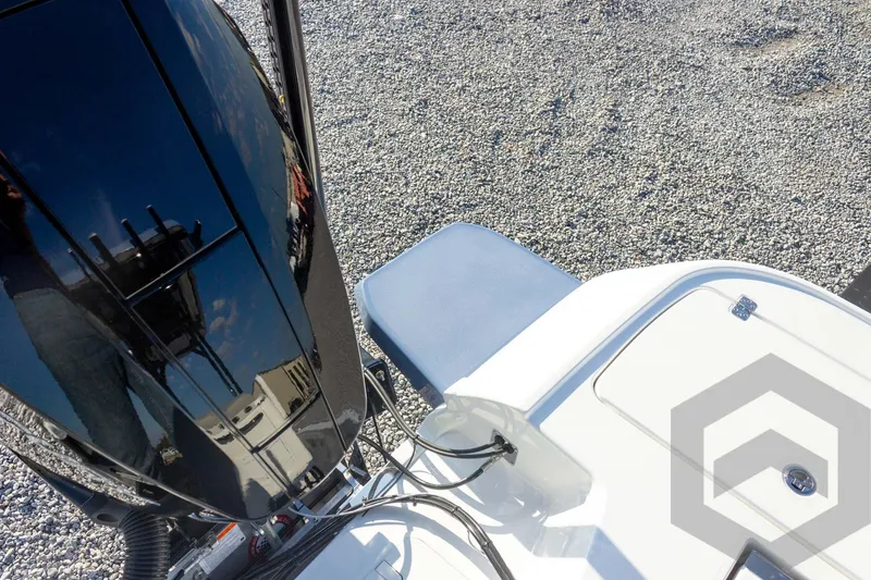 Slide: The Image of 2026 Caymas 26 HB boat engine and deck detail on gravel surface. - 64