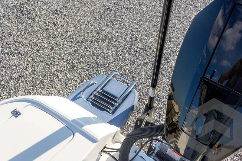 Slide: The Image of 2026 Caymas 26 HB boat with ladder and motor, on gravel surface. - 65