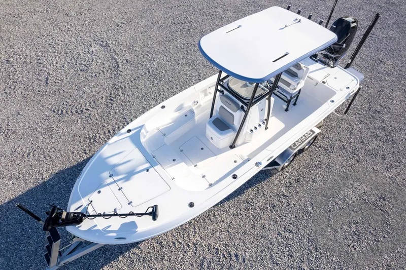 Slide: The Image of 2026 Caymas 26 HB boat, aerial view, white deck, modern design, parked on gravel. - 69