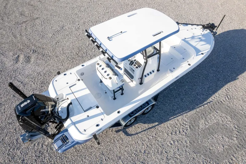 Slide: The Image of 2026 Caymas 26 HB boat on gravel, featuring sleek design and modern outboard motor. - 73
