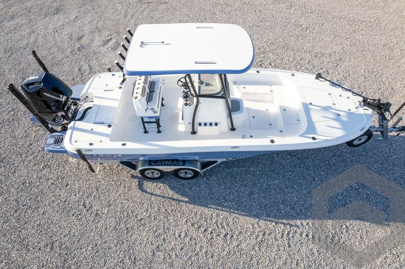 Slide: The Image of 2026 Caymas 26 HB boat on trailer, aerial view, parked on gravel surface. - 74