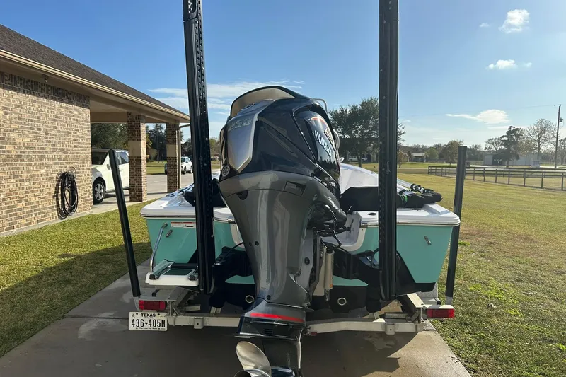 Slide: The Image of 2023 Sportsman Tournament 234 Bay Boat with Yamaha engine on trailer in driveway. - 12