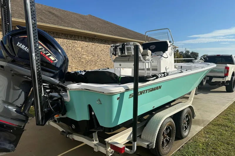 Slide: The Image of 2023 Sportsman Tournament 234 Bay Boat on trailer, featuring Yamaha engine, parked in driveway. - 13