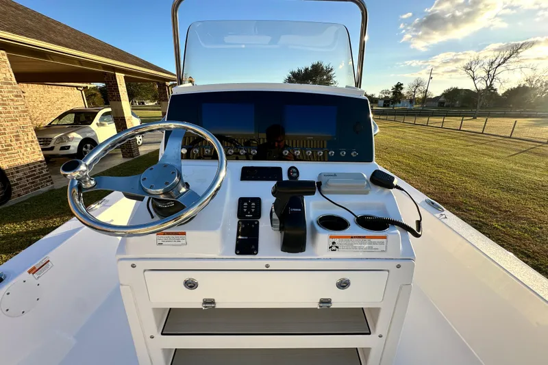 Slide: The Image of 2023 Sportsman Tournament 234 Bay Boat dashboard with steering wheel and controls. - 26