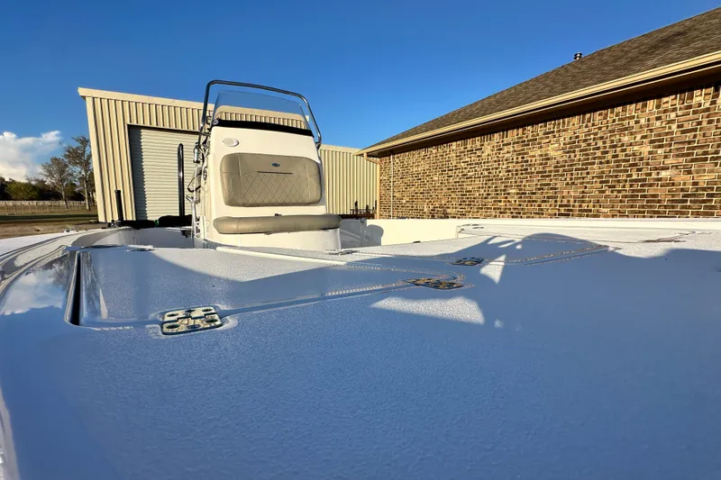 Slide: The Image of 2023 Sportsman Tournament 234 Bay Boat docked near a brick building under clear blue sky. - 35