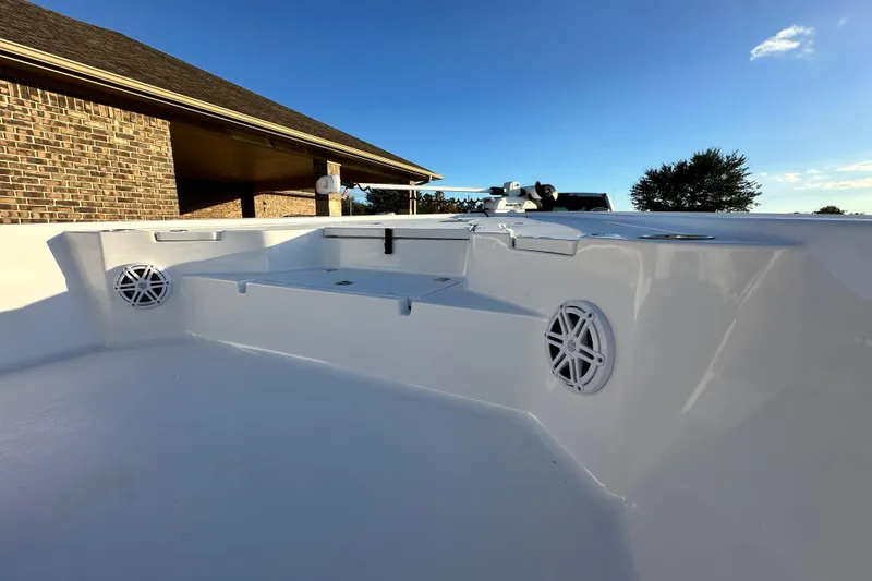 Slide: The Image of 2023 Sportsman Tournament 234 Bay Boat interior with speakers, under clear blue sky. - 38