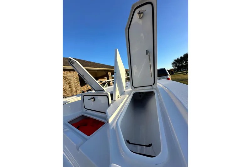 Slide: The Image of 2023 Sportsman Tournament 234 Bay Boat storage compartments open under clear blue sky. - 42