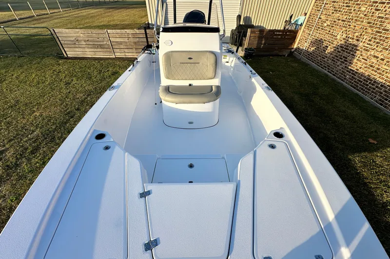 Slide: The Image of 2023 Sportsman Tournament 234 Bay Boat, spacious deck, open storage compartments, outdoor setting. - 50