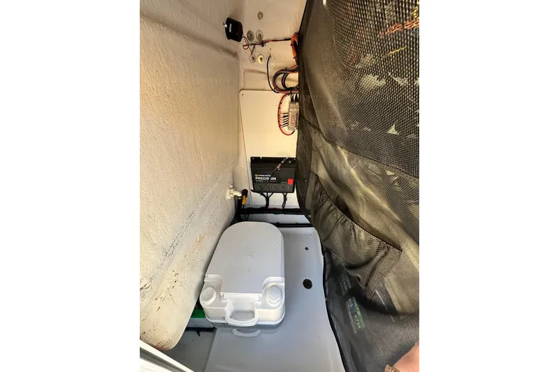 Slide: The Image of 2023 Sportsman Tournament 234 Bay Boat interior storage compartment with battery and cooler. - 54