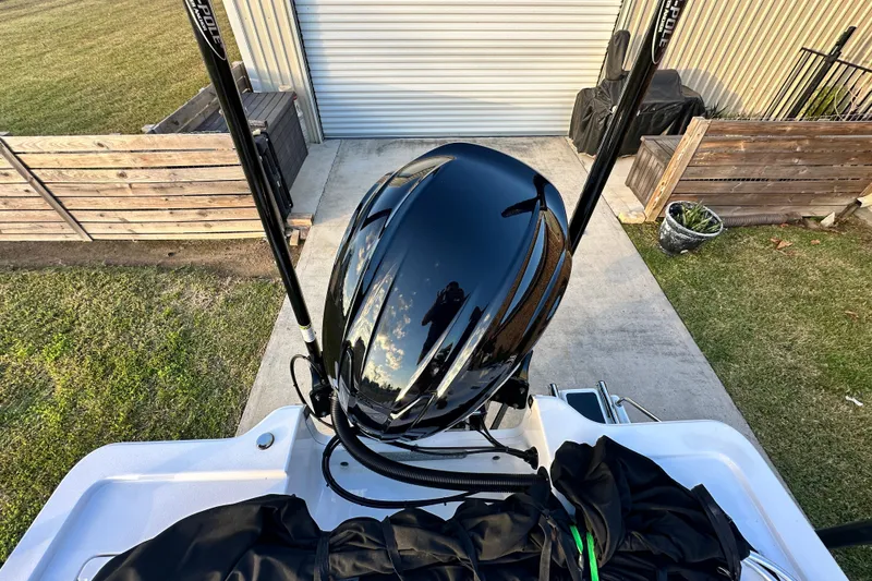 Slide: The Image of 2023 Sportsman Tournament 234 Bay Boat with sleek black engine, docked outdoors. - 63