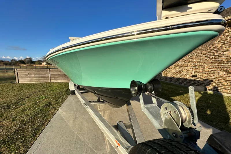 Slide: The Image of 2023 Sportsman Tournament 234 Bay Boat on trailer, vibrant teal hull, sunny day. - 9