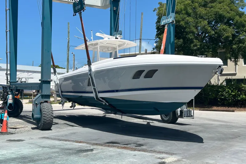 Slide: The Image of 2015 Intrepid 400 Cuddy boat being lifted by a crane at a marina. - 3