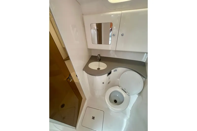 Slide: The Image of 2015 Intrepid 400 Cuddy boat bathroom with sink, toilet, and mirror. - 8