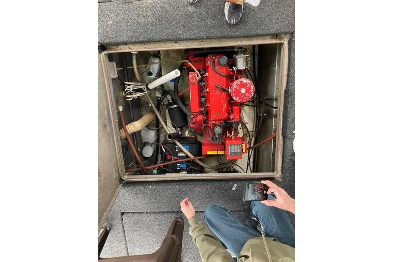 Slide: The Image of 1981 Sumerset Houseboat engine compartment with red engine and visible wiring. - 13