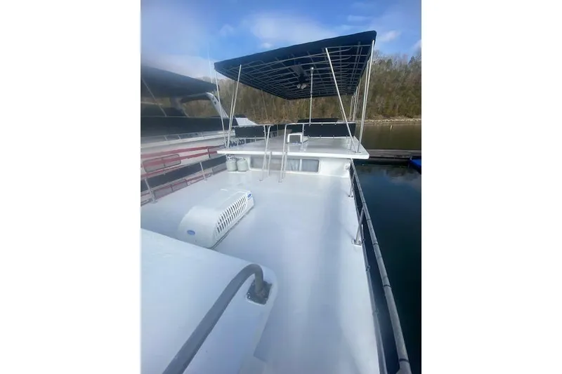 Slide: The Image of 1981 Sumerset houseboat with spacious deck and canopy, docked on a calm lake. - 15