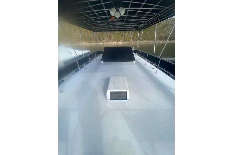 Slide: The Image of 1981 Sumerset Houseboat deck with canopy, overlooking serene water and lush greenery. - 16