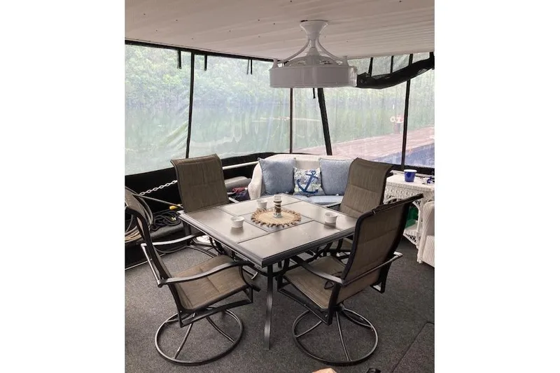 Slide: The Image of 1981 Sumerset houseboat interior with dining table, chairs, and cozy seating area. - 2