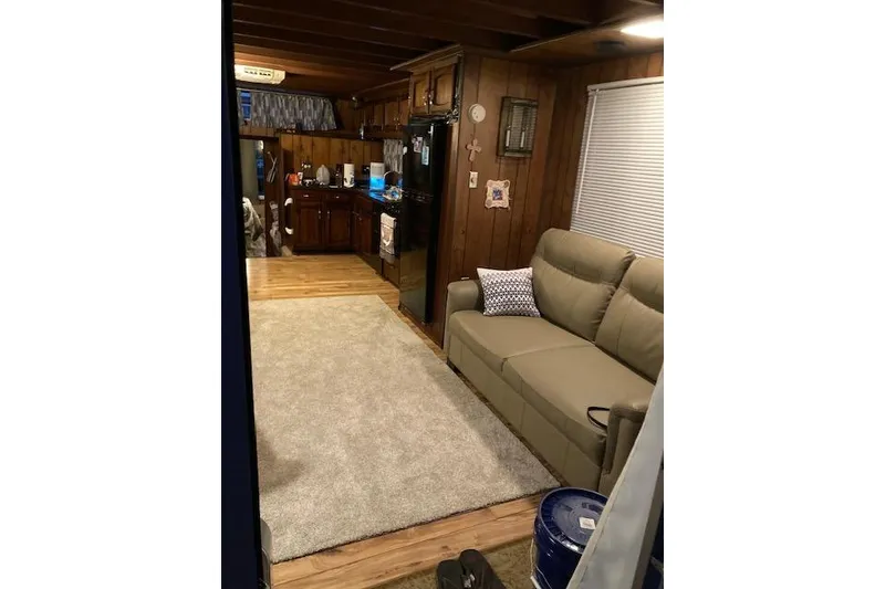 Slide: The Image of 1981 Sumerset houseboat interior with cozy living area, sofa, and kitchen. - 3