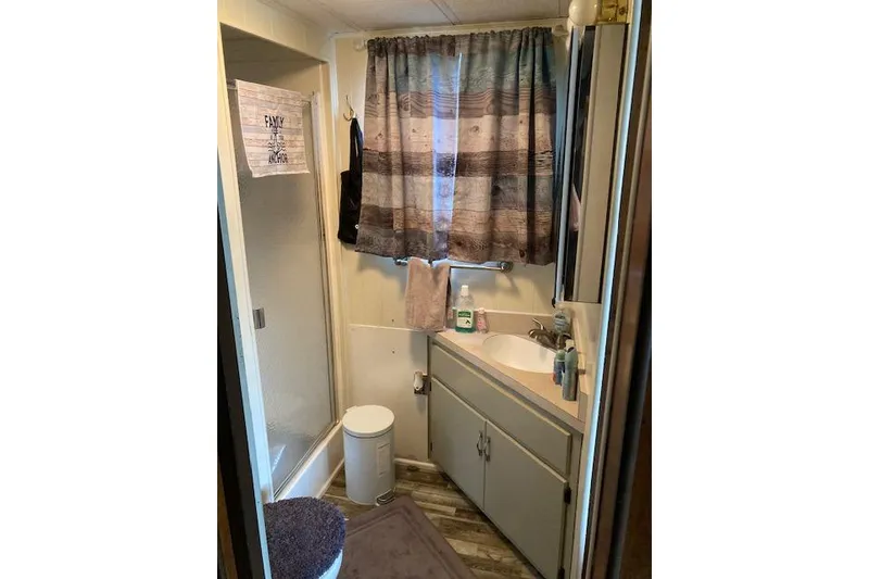 Slide: The Image of 1981 Sumerset houseboat bathroom with shower, sink, and rustic decor. - 9