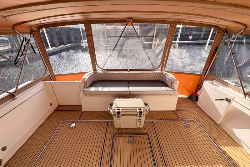 Slide: The Image of 2007 Albin 45 Command Bridge interior with cushioned seating and wooden flooring. - 13
