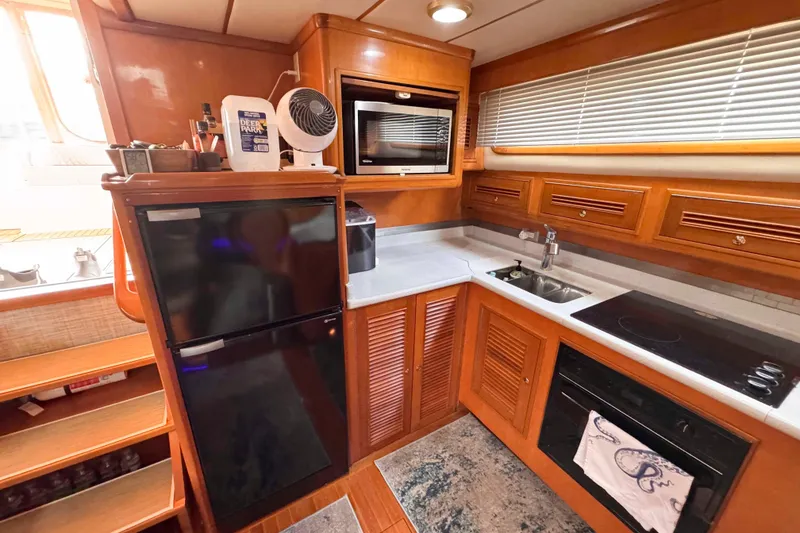 Slide: The Image of 2007 Albin 45 Command Bridge kitchen with fridge, microwave, sink, and stove. - 21