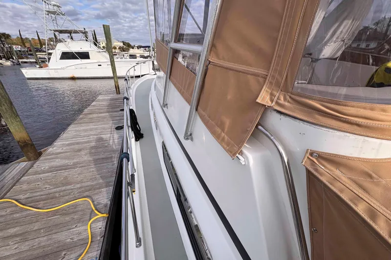 Slide: The Image of 2007 Albin 45 Command Bridge docked, featuring tan canvas covers and marina view. - 8