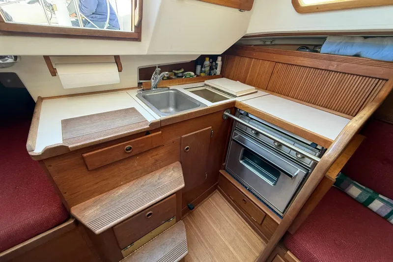 Slide: The Image of Compact kitchen in 1986 Sabre 30 MKIII sailboat with sink, stove, and wooden cabinetry. - 33