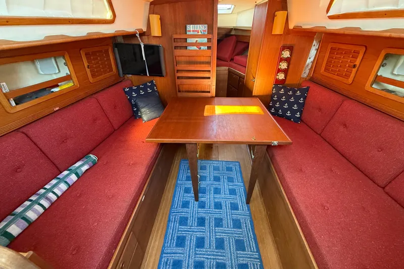 Slide: The Image of Interior of 1986 Sabre 30 MKIII sailboat with red seating and wooden table. - 35