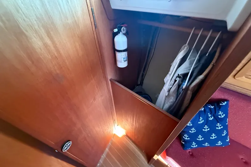 Slide: The Image of Wooden closet interior on 1986 Sabre 30 MKIII sailboat with fire extinguisher and hanging clothes. - 37