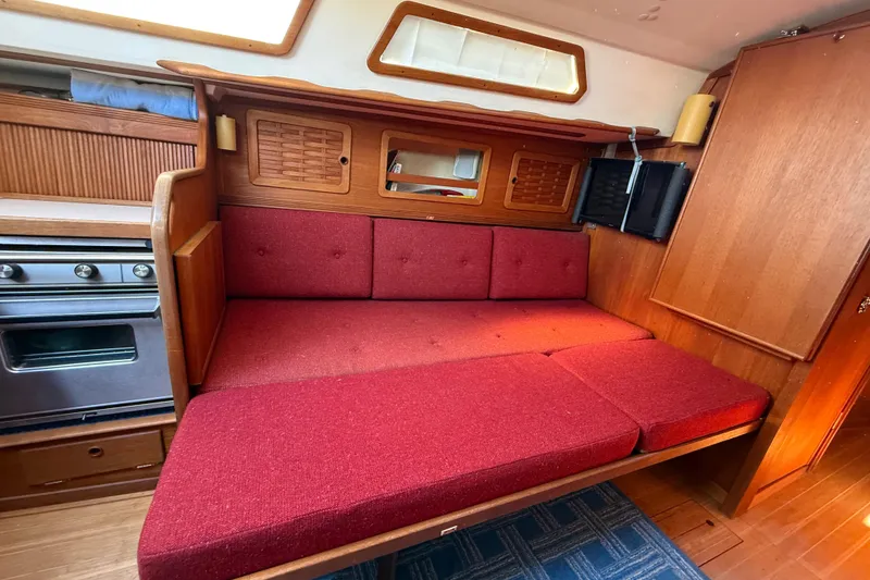 Slide: The Image of Interior of 1986 Sabre 30 MKIII sailboat with red cushioned seating and wooden cabinetry. - 41