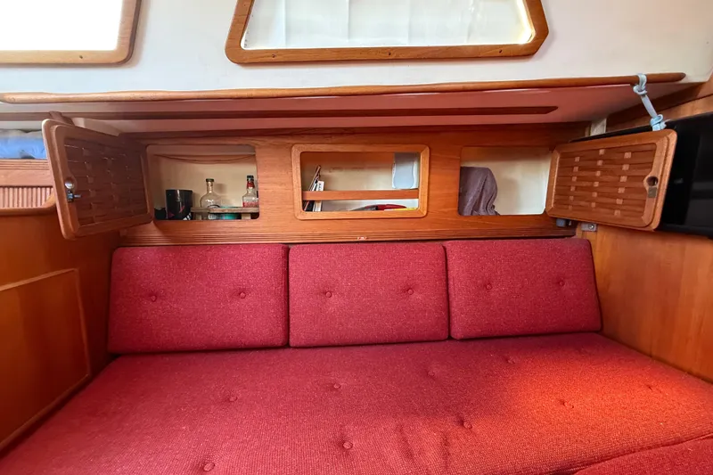 Slide: The Image of Interior of 1986 Sabre 30 MKIII sailboat with red cushions and wooden cabinetry. - 42