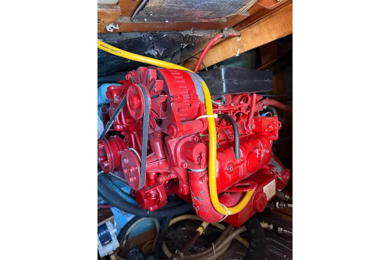 Slide: The Image of Red engine of a 1986 Sabre 30 MKIII sailboat, featuring visible belts and hoses. - 44