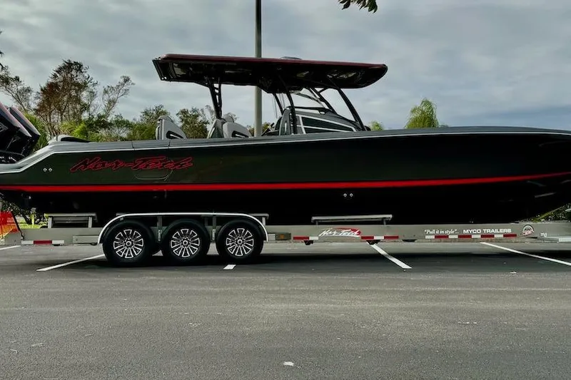 The Image of 2025 Nor-Tech 390 Sport Center Console boat on trailer, parked outdoors. - 0